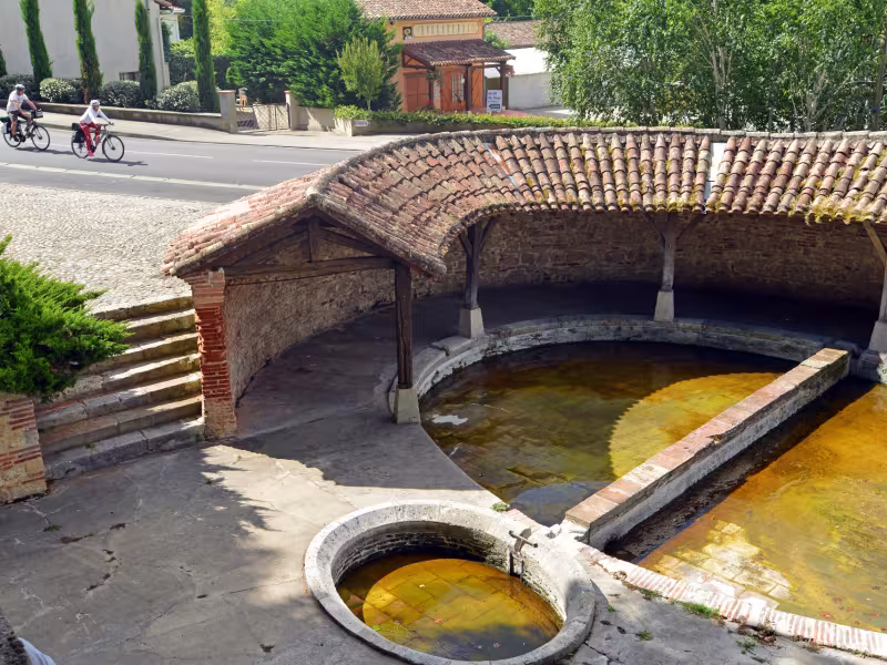 Cyclistes devant le plus ancien lavoir de Valence d'Agen 